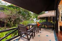 a patio with a table and chairs on a porch at Palm Leaf Resort Koh Tao in Ko Tao