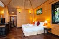 a bedroom with a white bed and a television at Palm Leaf Resort Koh Tao in Ko Tao