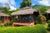 a hut with a thatch roof and a porch at Palm Leaf Resort Koh Tao in Ko Tao