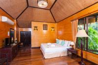 a bedroom with a bed and a television in a room at Palm Leaf Resort Koh Tao in Ko Tao