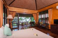 a bedroom with a bed and a living room at Palm Leaf Resort Koh Tao in Ko Tao