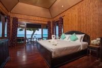 a bedroom with a bed with a view of the ocean at Palm Leaf Resort Koh Tao in Ko Tao