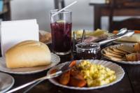 a table with plates of food and a drink at Hotel Marina Clube de Pesca in Cananéia