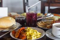 a table topped with plates of breakfast food and a drink at Hotel Marina Clube de Pesca in Cananéia