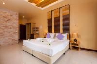 a bedroom with a large white bed with purple pillows at Palm Leaf Resort Koh Tao in Ko Tao