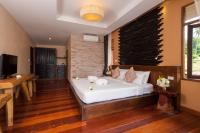 a bedroom with a white bed with a brick wall at Palm Leaf Resort Koh Tao in Ko Tao