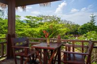 a table and two chairs on a porch with a view at Palm Leaf Resort Koh Tao in Ko Tao