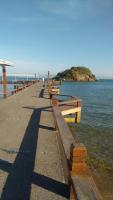 a row of benches on a pier near the water at Pousada Portico de Buzios in Armacao dos Buzios