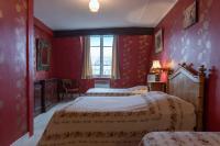 a red bedroom with two beds and a window at Hotel Esmeralda in Paris