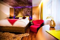 a hotel room with a bed and a red chair at Hotel de l'Opera Hanoi - MGallery in Hanoi
