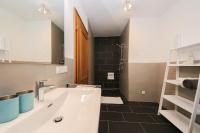 a bathroom with a white sink and a black tile floor at Ferienwohnungen Wartbichler in Lofer