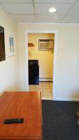 a living room with a black refrigerator and a table at Atlantic Motel in Point Pleasant Beach