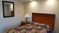 a bedroom with a bed and a lamp and a mirror at Atlantic Motel in Point Pleasant Beach
