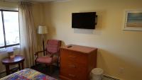 a bedroom with a dresser and a tv on the wall at Atlantic Motel in Point Pleasant Beach