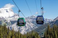 two gondolas on a ski lift in front of a mountain at Sunshine Mountain Lodge in Banff