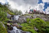a group of people standing on a bridge over a waterfall at Sunshine Mountain Lodge in Banff