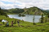 three people standing on a hill looking at a lake at Sunshine Mountain Lodge in Banff