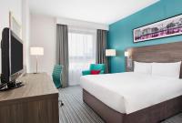 a hotel room with a large bed and a flat screen tv at Leonardo Hotel Belfast in Belfast