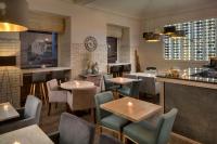 a restaurant with tables and chairs and a bar at Hotel Florenc in Prague