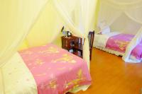 a bedroom with two beds and a canopy at Spring Garden Homestay in Hualien City