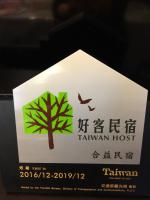 a sign with a tree and a bird on it at Heyi B&amp;B in Taitung City