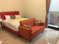 a bedroom with a bed and a red chair at Heyi B&amp;B in Taitung City