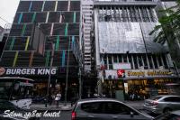 a busy city street with cars parked in front of buildings at Silom Space Hostel in Bangkok