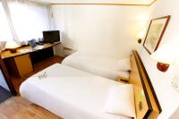 Una habitación de hotel con dos camas y un escritorio. en Campanile Dunkerque Est - Armbouts-Cappel, en Armbouts-Cappel
