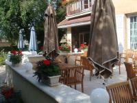 a patio with umbrellas and tables and chairs at Logis Hôtel-Restaurant Les Airelles in Neufchâtel-en-Bray