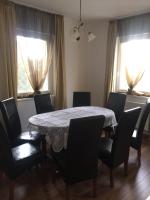 a dining room with a table and chairs and windows at Mimi Apartment in Nyíregyháza