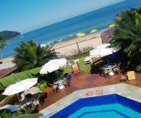 a view of a swimming pool and the beach at Pousada DiMari in Boicucanga