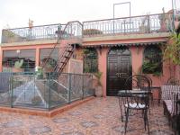 Un patio con una mesa y sillas frente a una casa. en Sindi Sud, en Marrakech