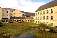 a group of buildings next to a body of water at Logis Hôtel Le Relais du Moulin in Valençay