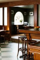 een restaurant met een bar met krukken en tafels bij Anvil Hotel in Jackson