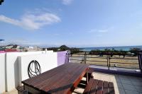 a wooden table on a balcony with a view of the ocean at Tz Shin Resort Hostel in Kenting