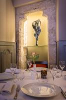 Una mesa en un restaurante con una mesa puesta con copas de vino. en Hôtel Aux Vieux Remparts, en Provins