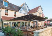 Un restaurante con mesas y sillas frente a un edificio. en Hôtel Aux Vieux Remparts, en Provins