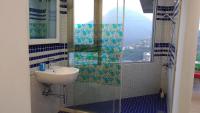 a bathroom with a sink and a shower with a window at Good Time B&amp;B in Jiufen