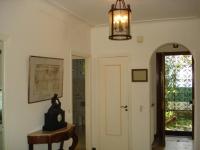 un pasillo con una puerta y un reloj sobre una mesa en Villa Eden, en Menton