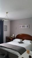 - une chambre avec un grand lit et une tête de lit en bois dans l&#39;établissement Le Petit Manoir Logis, aux Angles (Gard)