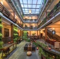 大理市にあるDali Yanyuan Mountain Retreatの植物、テーブル、ベンチのある屋内ロビー