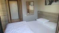 a bedroom with two white beds and a mirror at SunAnatolia Otel in Antalya