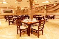 アラーにあるHala Inn Hotelの木製のテーブルと椅子のあるダイニングルーム