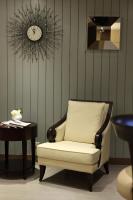 a chair and a table with a clock on the wall at Green World Mai - NanJing in Taipei