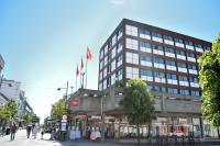 un edificio con banderas encima en una calle en Thon Partner Hotel Kristiansand, en Kristiansand