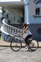 a woman is riding a bike on the street at PortoBay Serra Golf in Santo António da Serra