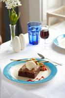 a piece of cake on a table with a glass of wine at PortoBay Serra Golf in Santo António da Serra