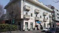 Un gran edificio blanco con balcones en una calle. en Hotel Ponte Sassi, en Turín