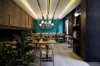 a restaurant with tables and chairs and a chandelier at Axel Hotel Barcelona - Adults Only in Barcelona