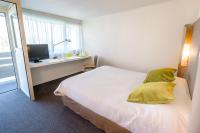 a bedroom with a bed and a desk with a television at Campanile Toulouse Sesquieres in Toulouse